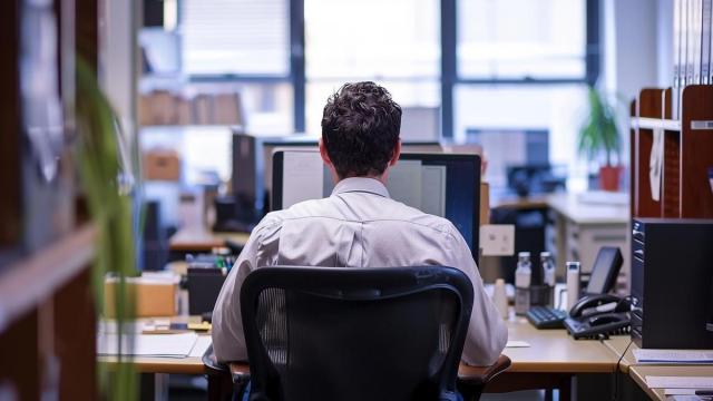 Un hombre maneja un ordendor en el desempeño de su trabajo.