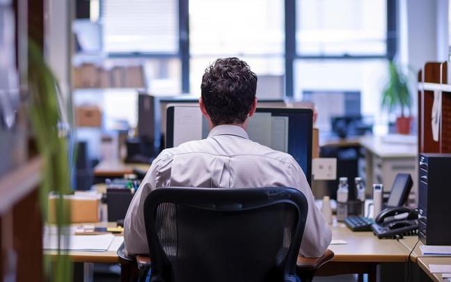 Un hombre maneja un ordendor en el desempeño de su trabajo.