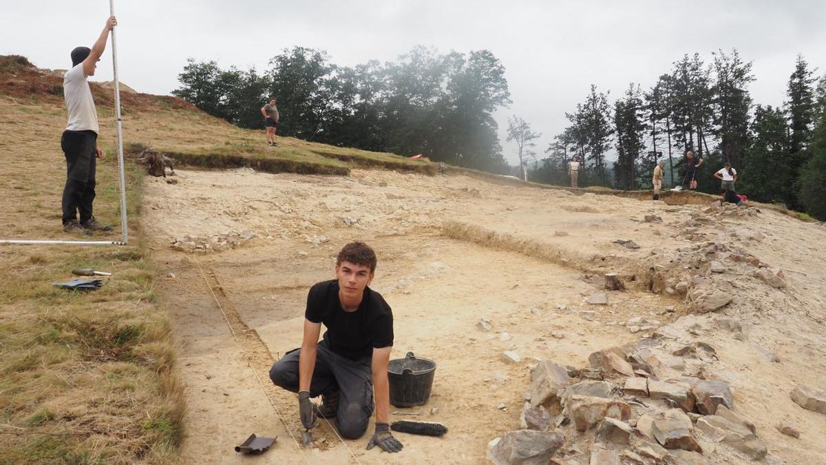 Unos jóvenes trabajan junto a los restos de la muralla que rodeó al asentamiento de Muonaundi durante las excavaciones de 2024