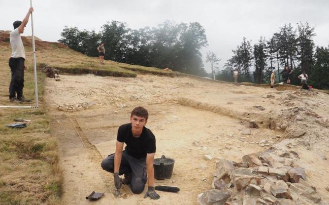 Unos jóvenes trabajan junto a los restos de la muralla que rodeó al asentamiento de Muonaundi durante las excavaciones de 2024