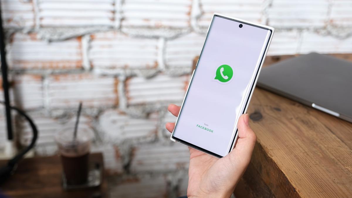 Un usuario abre la app de WhatsApp en su móvil.