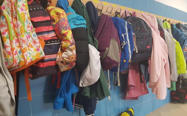 Mochilas colgadas en los percheros de un colegio. Mochilas colgadas en los percheros de un colegio.