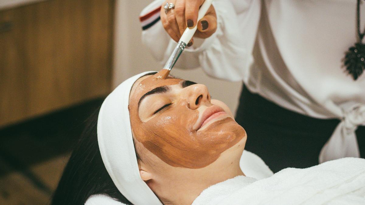 Una mujer recibe un tratamiento facial en una clínica.