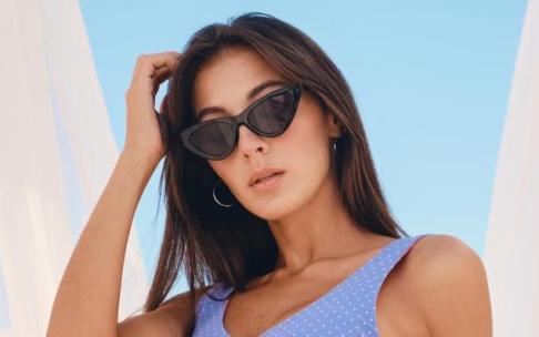 Una mujer joven con gafas de sol negras.