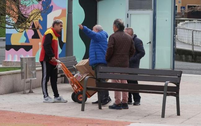 Unos vecinos de Zumarraga indican a un repartidor cómo ir a Urretxu.