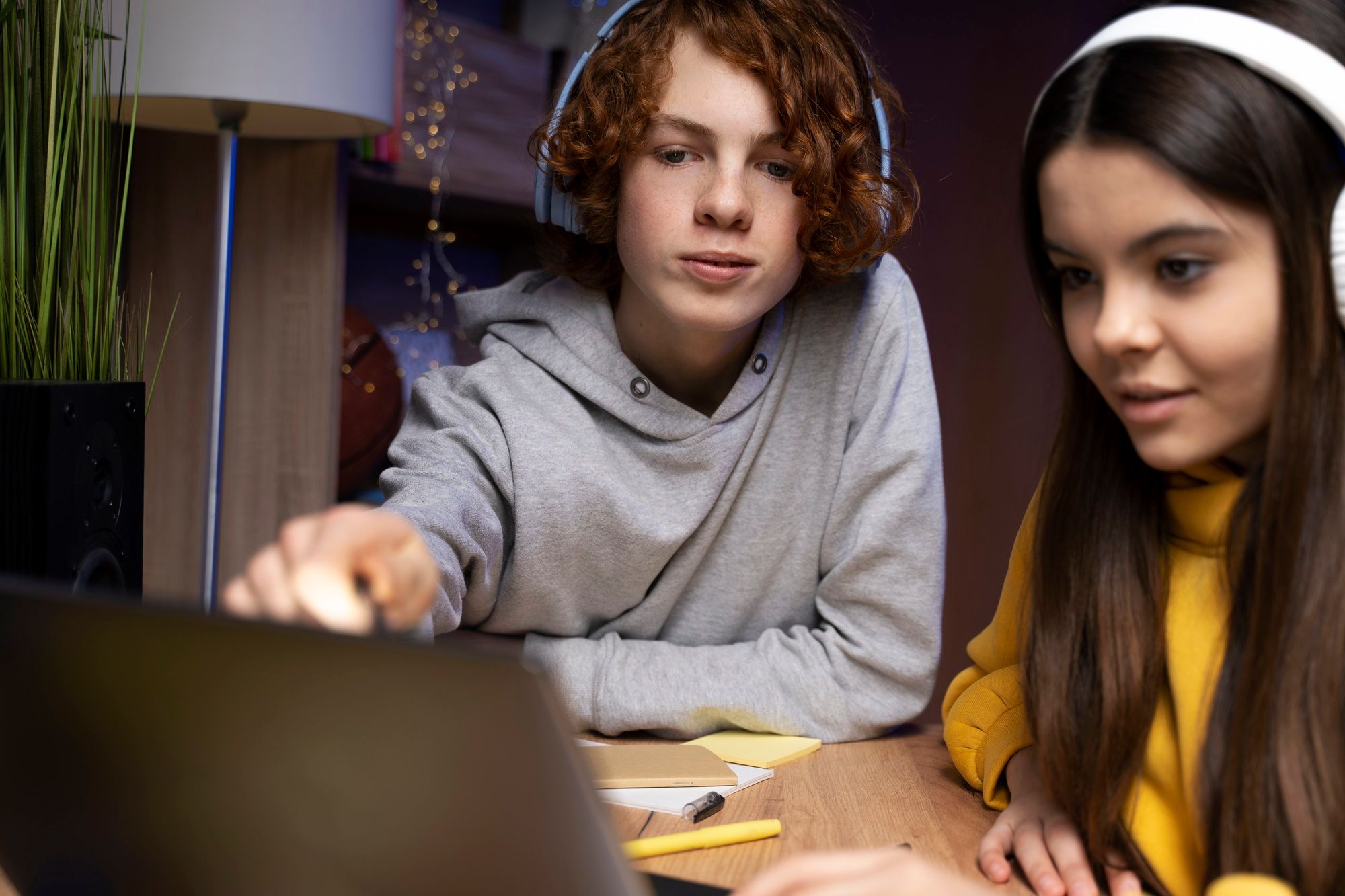 Dos adolescentes estudian con un ordenador portátil.