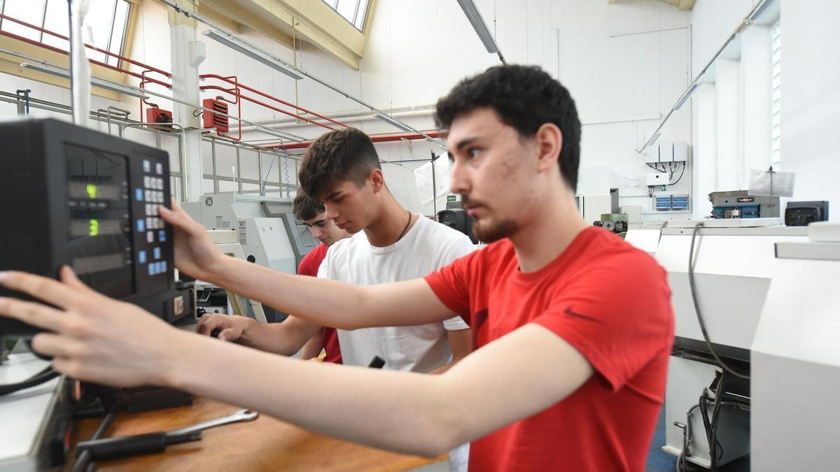 Estudiantes de FP realizando prácticas en un taller de mecanizado.