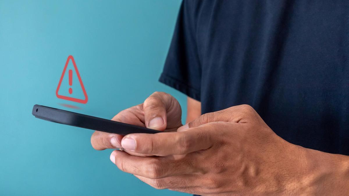 Un ususario recibe un aviso de alerta en su teléfono móvil.