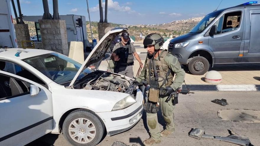 Agentes de la Policía y militares de Israel inspeccionan el vehículo de los atacantes.