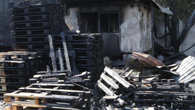 Palés de madera calcinados tras incendiarse durante un ataque nocturno ruso con drones, en un aparcamiento cercano a un centro comercial y de ocio de Dnipró.
