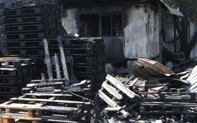 Palés de madera calcinados tras incendiarse durante un ataque nocturno ruso con drones, en un aparcamiento cercano a un centro comercial y de ocio de Dnipró.