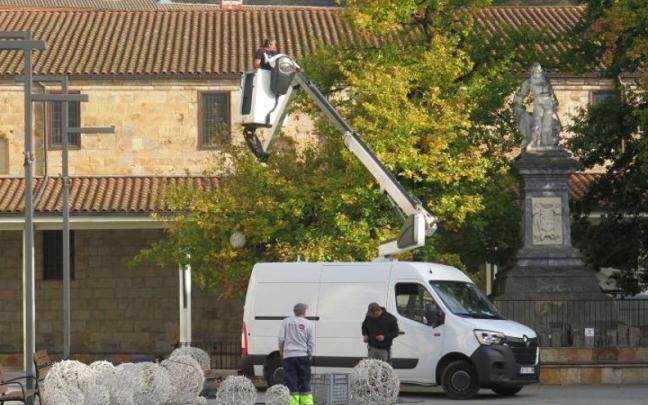 Los operarios, colocando las luces de Navidad en la plaza Iparragirre de Urretxu.