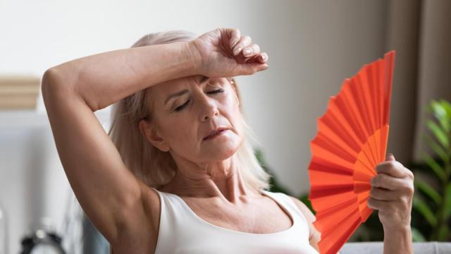Una mujer con sofocos durante la menopausia.