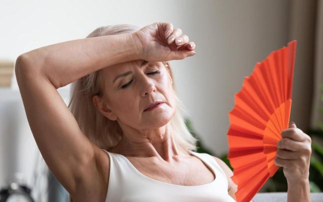 Una mujer con sofocos durante la menopausia.