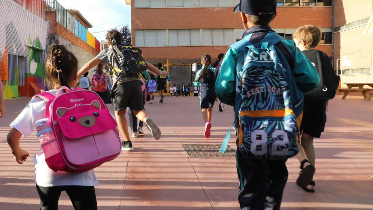 Varios niños llegando al colegio.