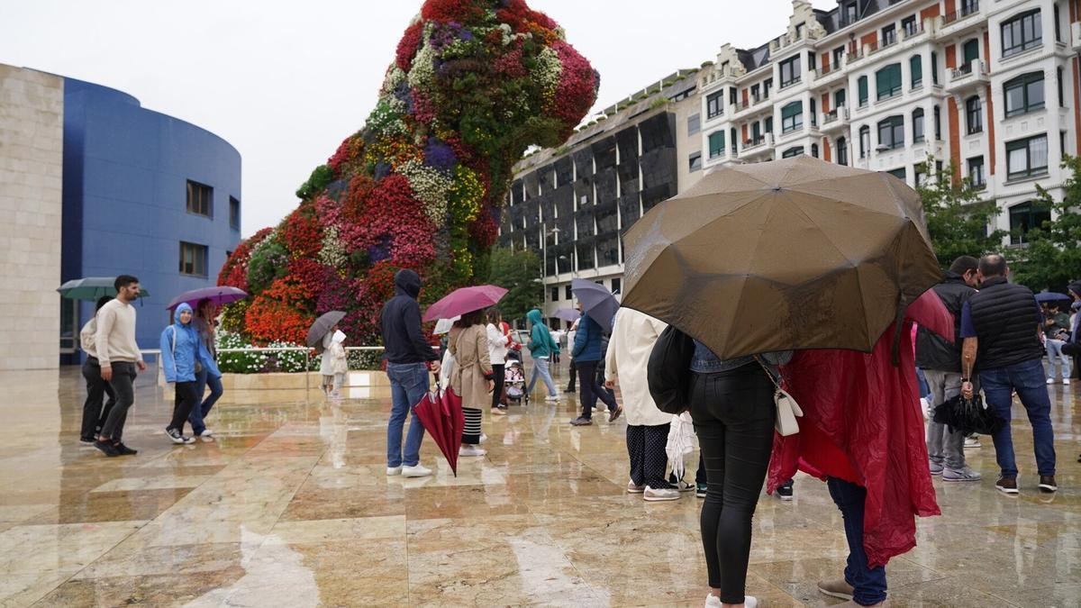 Turistas disfrutan del Museo Guggenheim con lluvia en Bilbao