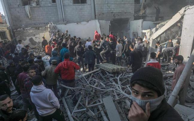 Varios palestinos buscan supervivientes en los escombros de un edificio en Al Nusairat, al sur de Gaza.