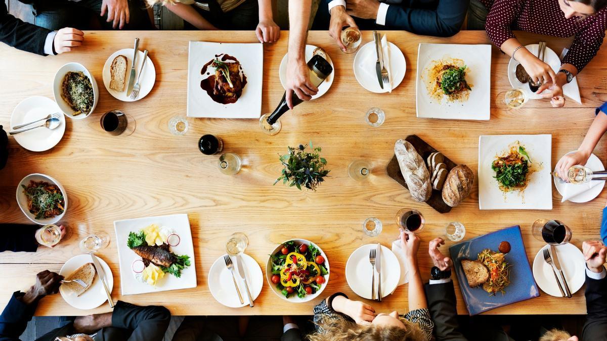 Unas cuantas personas comen juntas en un restaurante.