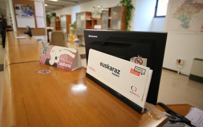 Un cartel en una oficina de una administración pública advierte al usuario de que el funcionario que está al otro lado del mostrador puede atenderle en euskera.