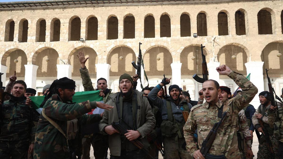 Combatientes sirios celebran en Damasco la caída del régimen de Al Asad.