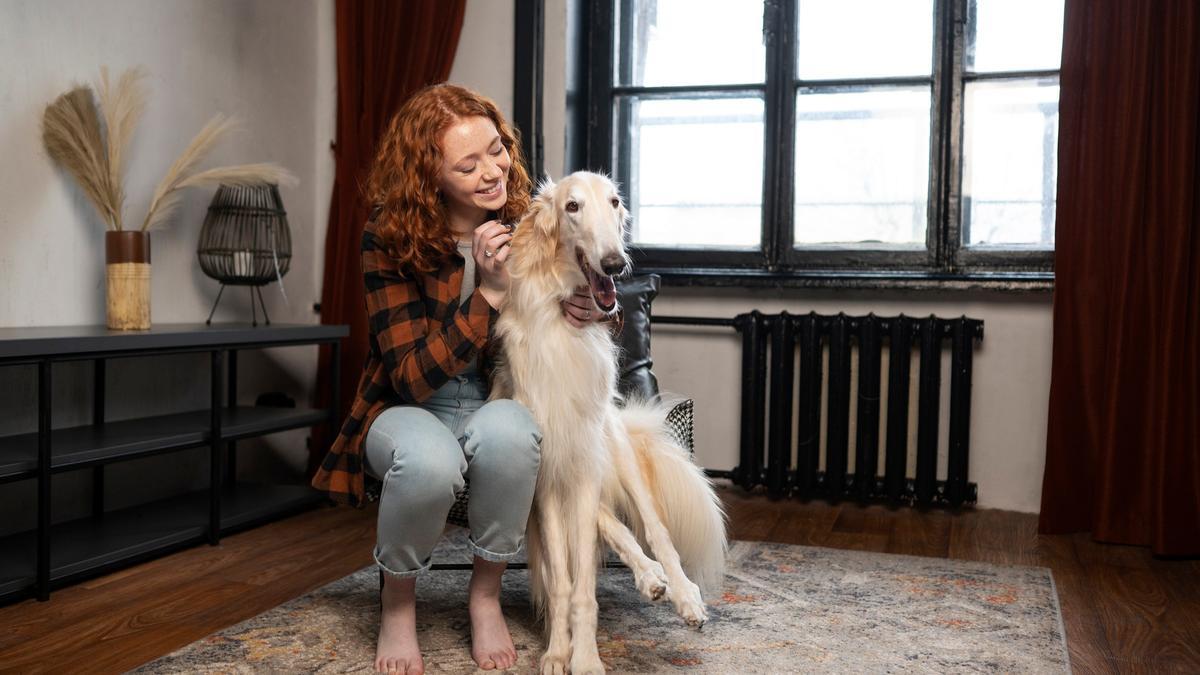 Mujer sonriendo junto a su perro.