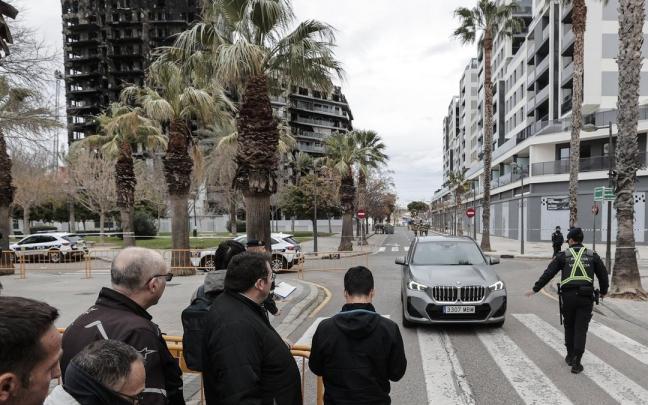 Un vecino retira su coche del edificio incendiado mientras otros esperan para hacerlo también, este domingo.