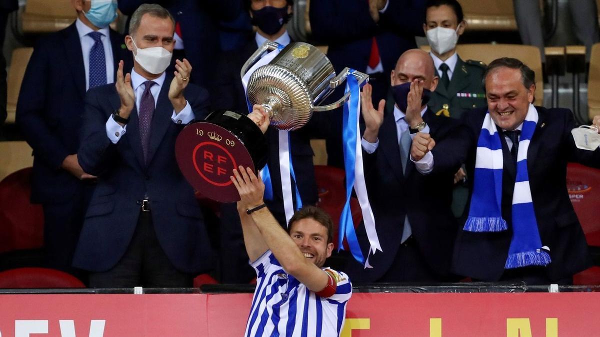 Asier Illarramendi levanta la Copa 2019-20 en La Cartuja, ante Felipe IV, Luis Rubiales y Jokin Aperribay. / EFE