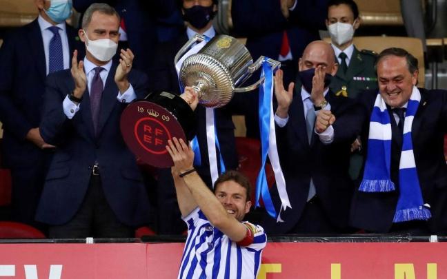 Asier Illarramendi levanta la Copa 2019-20 en La Cartuja, ante Felipe IV, Luis Rubiales y Jokin Aperribay. / EFE