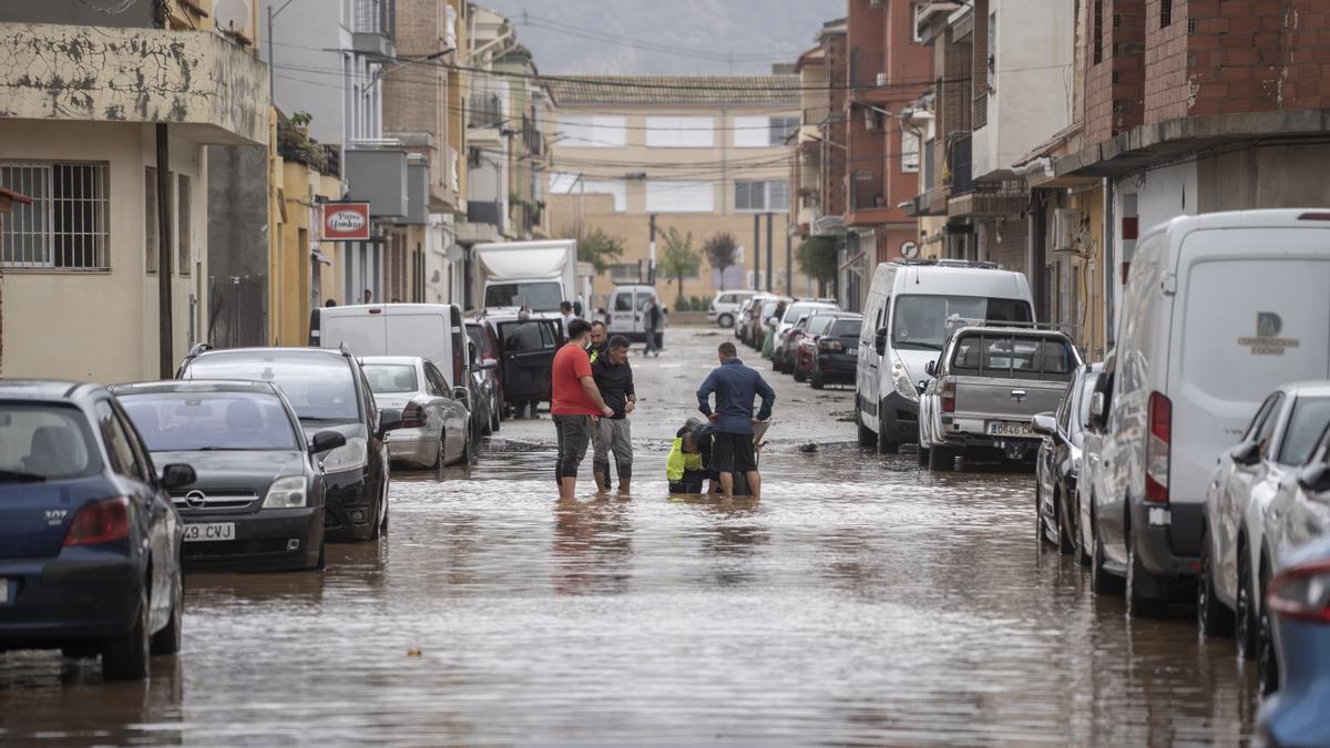 Varias personas observan los estragos ocasionados por la DANA en Llombai, Valencia