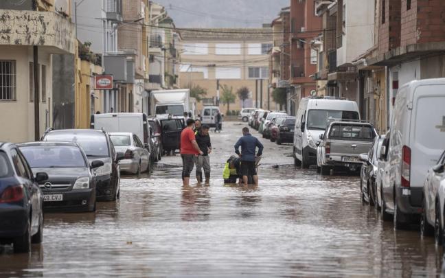 Varias personas observan los estragos ocasionados por la DANA en Llombai, Valencia