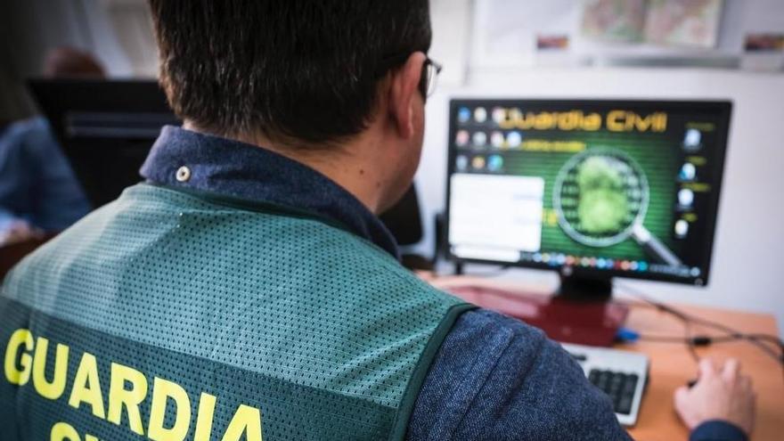 Un agente de la Guardia Civil maneja un ordenador.