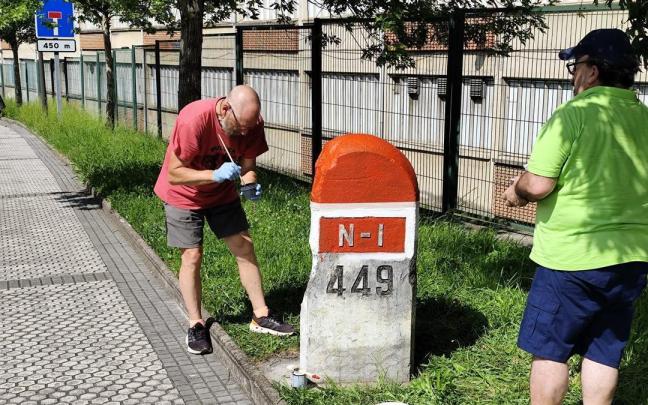 Dos miembros de Burdina pintando un mojón.