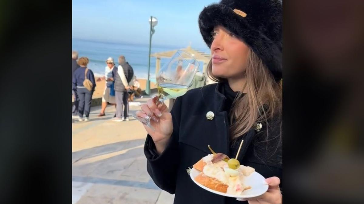 La influencer, comiendo y bebiendo frente a la playa de Zarautz.