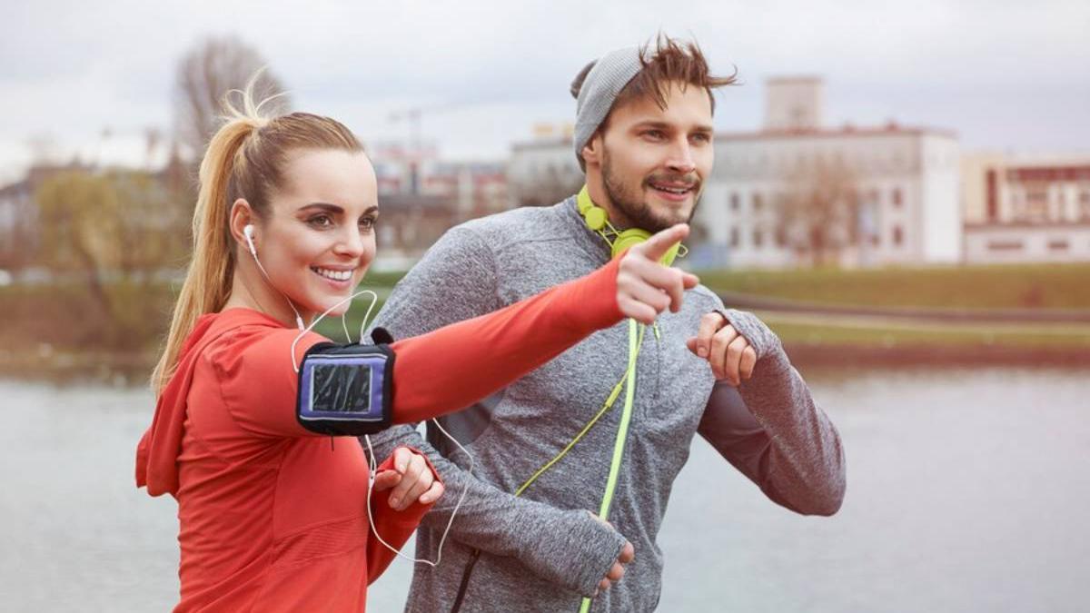 Pareja salen a correr juntos mientras sonríen y mantienen una conversación agradable