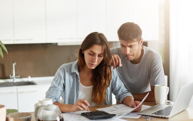 Una joven pareja hace cuentas para ver el estado de sus finanzas.