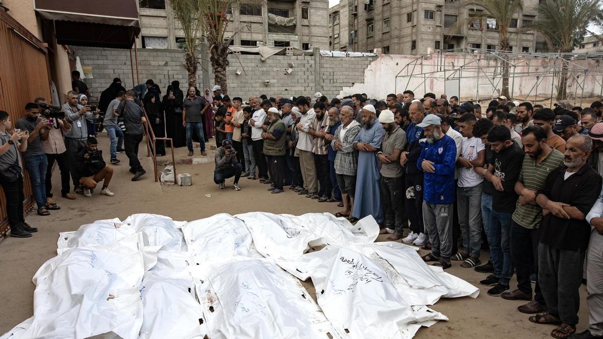 Palestinos rezan junto a los cadáveres de los miembros de la familia Abu Taima, muertos en un ataque israelí en Khan Younis.