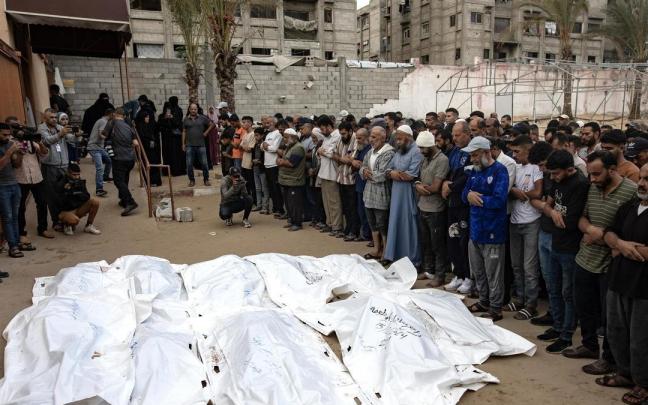 Palestinos rezan junto a los cadáveres de los miembros de la familia Abu Taima, muertos en un ataque israelí en Khan Younis.