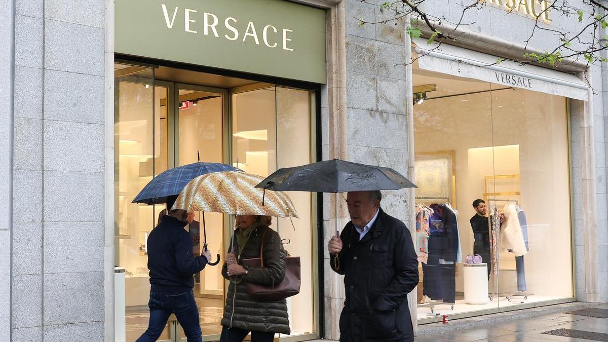 Varios transeúntes ante una tienda de Versace en Madrid.