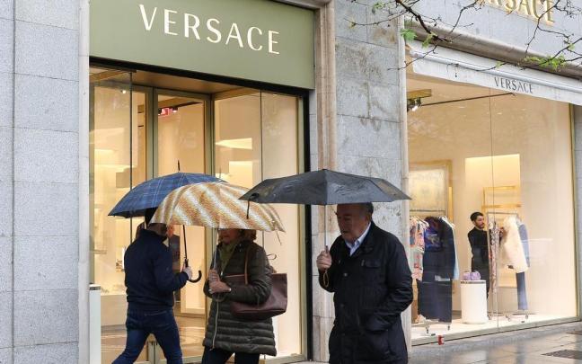 Varios transeúntes ante una tienda de Versace en Madrid.
