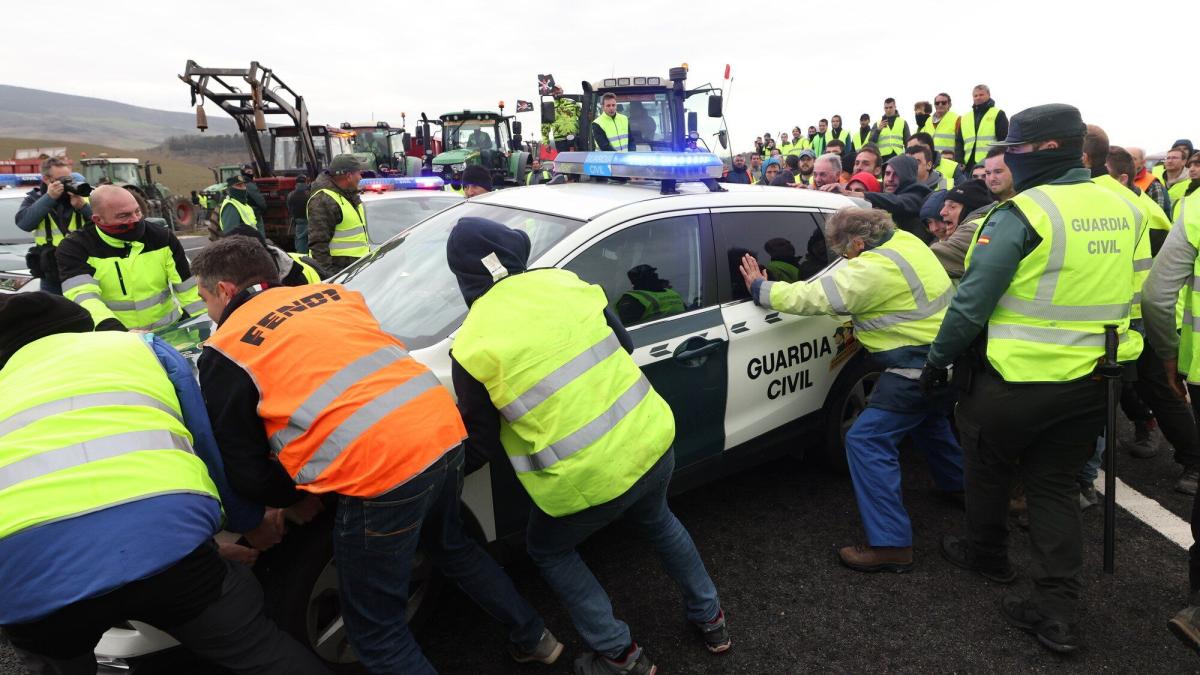 Agricultores y ganaderos empujan una patrulla de Guardia Civil que les impedía el acceso a la Autovía del Camino. Foto: Unai Beroiz