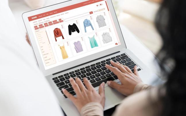 Una mujer mira en su portátil la página web de una marca de ropa.