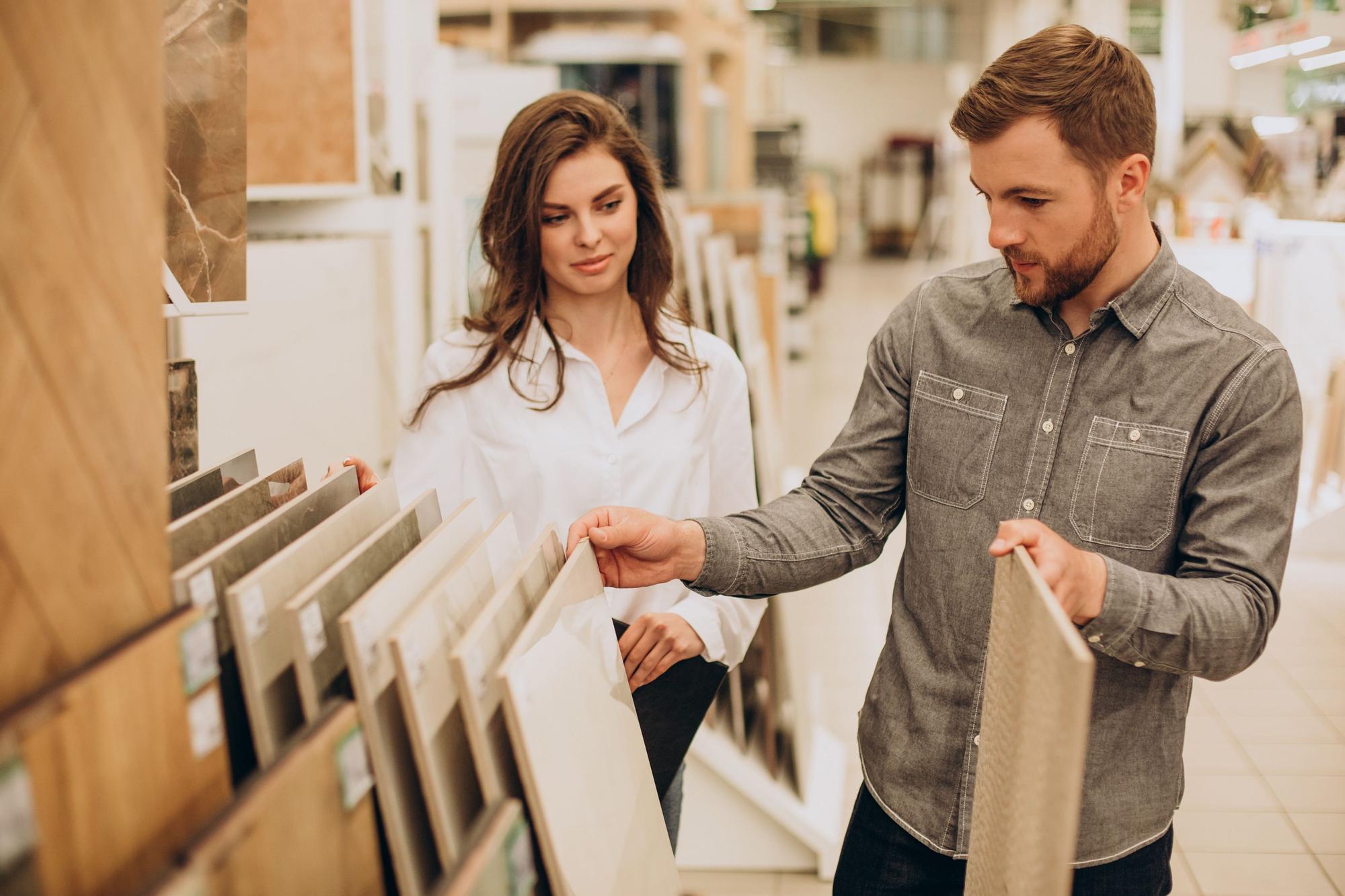 Pareja elige los materiales para su vivienda en una tienda de decoración.