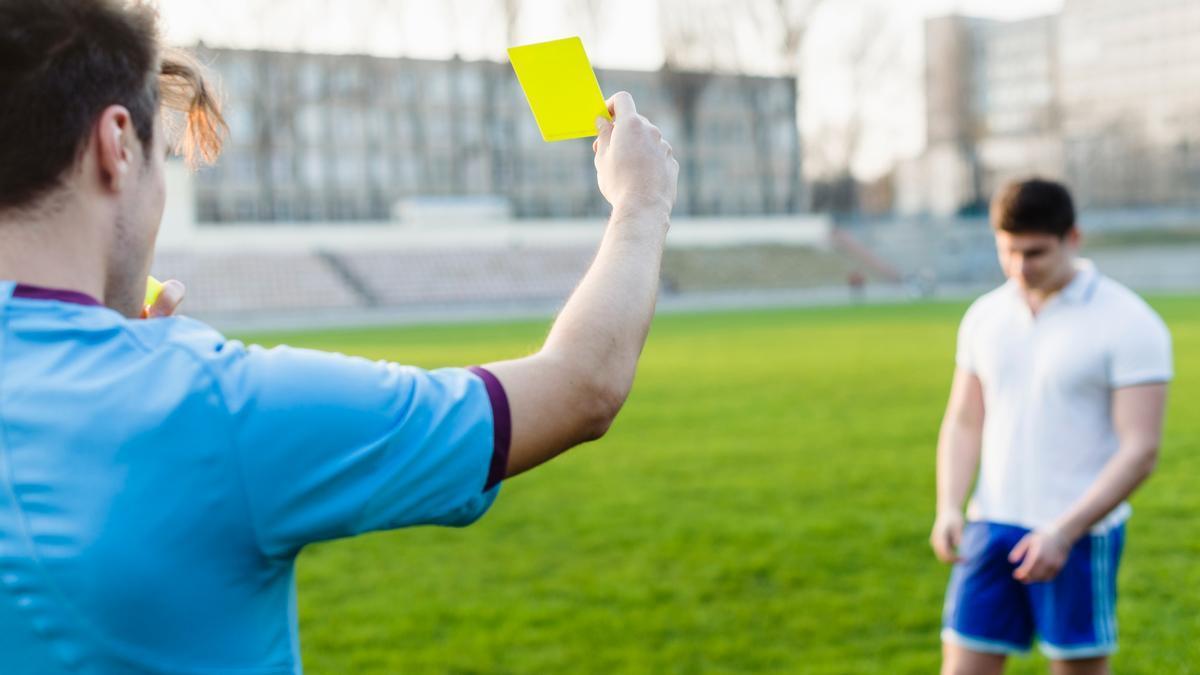 Imagen de archivo de un árbitro mostrando una tarjeta amarilla.
