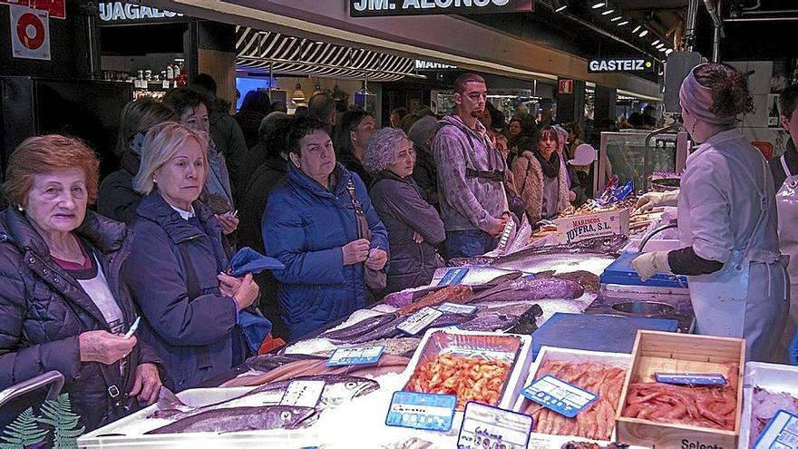 Clientes esperando su turno en una pescadería en la vitoriana Plaza de Abastos. | FOTO: ALEX LARRETXI