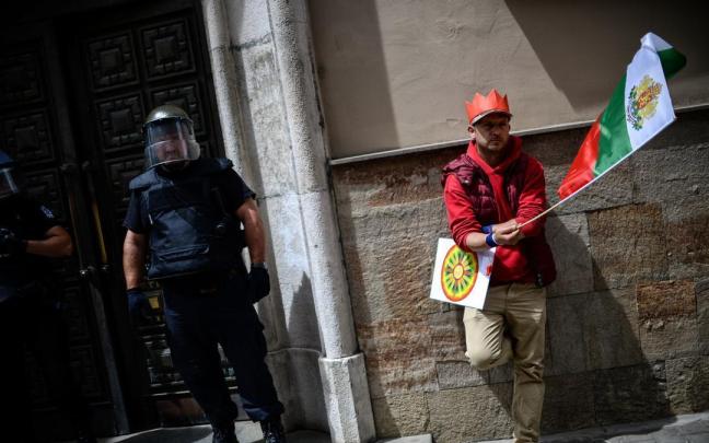 Un hombre ondea una bandera nacional durante una protesta ante el Parlamento búlgaro.