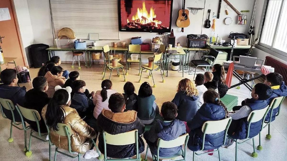 Los alumnos, frente a la pantalla con el fuego virtual en la clase de música.