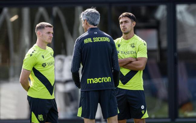 Sergio Gómez y Zubimendi charlan con Imanol, durante el entrenamiento vespertino de este lunes en Zubieta. / REAL SOCIEDAD