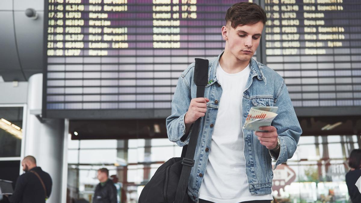 Un joven espera la salida de su vuelo en un aeropuerto.