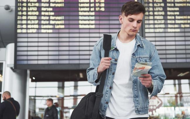 Un joven espera la salida de su vuelo en un aeropuerto.