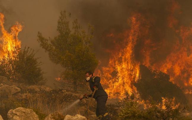 Un bombero lucha contra las llamas en Hasia, cerca de Atenas. Un bombero lucha contra las llamas en Hasia, cerca de Atenas.